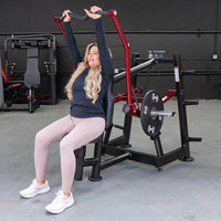 Thumbnail for Woman using a red and black overhead triceps extension machine with weight plates in a gym.