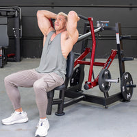 Thumbnail for Man in gray tank top using a red and black overhead triceps extension machine with weight plates.