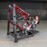 Thumbnail for Woman performing squats on a red and black Power Leverage V2 Pendulum Squat machine with a 25lb weight plate.