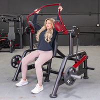 Thumbnail for Woman using a red and black Power Leverage V2 Pullover machine in a gym.