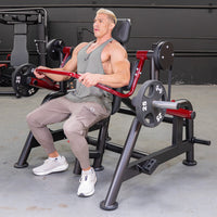 Thumbnail for Man in a gym using a red and black Power Leverage V2 Pullover machine with 25lb weights.
