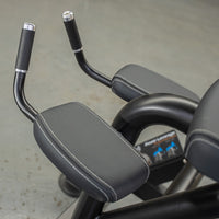 Thumbnail for Close-up of black gym equipment with padded armrests and handles, white stitching visible.