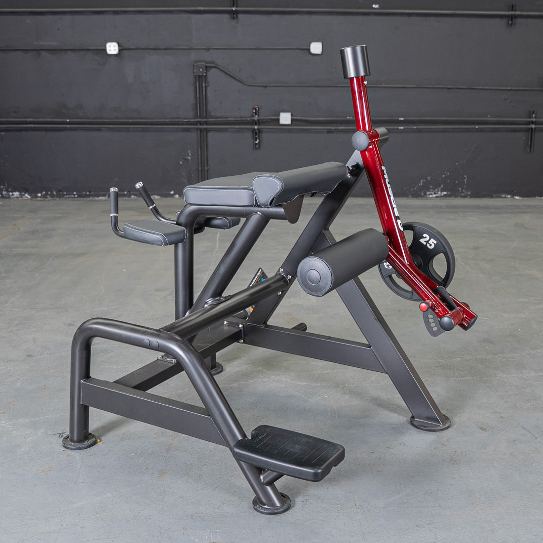 Black and red reverse hyper machine with a 25lb weight plate in a gym setting.