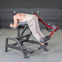 Thumbnail for Man using a black and red reverse hyper machine with a weight plate attached.