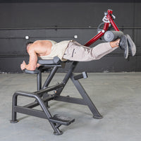 Thumbnail for Man using a Power Leverage V2 Reverse Hyper machine in a gym, lying face down with legs extended.