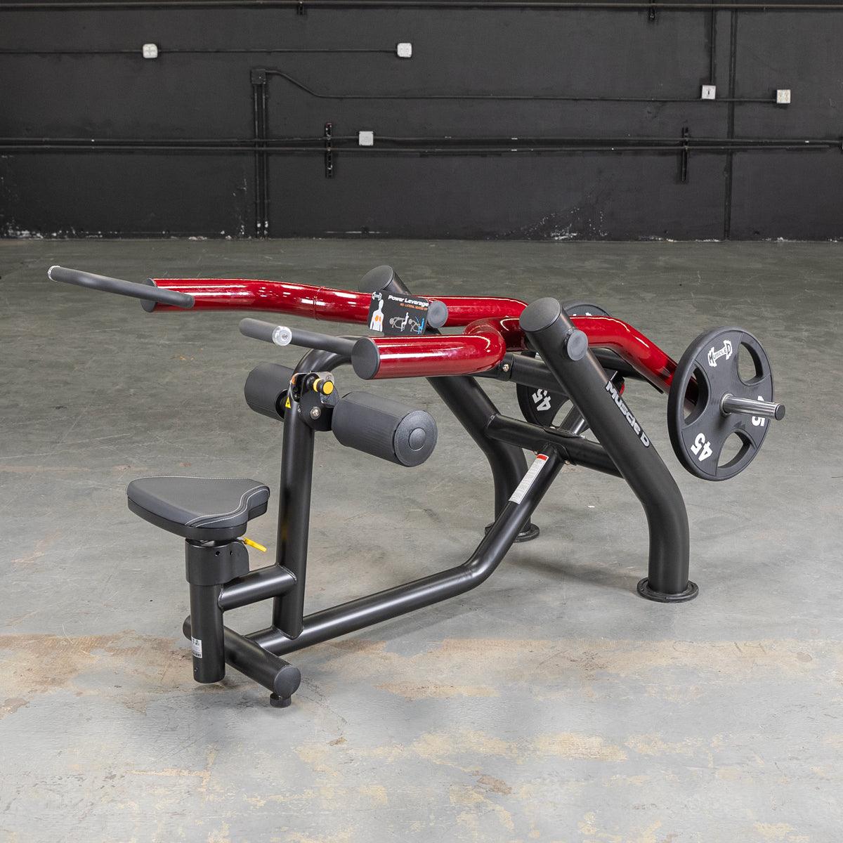 Black and red seated dip/triceps press machine with a 45lb weight plate on a concrete floor.