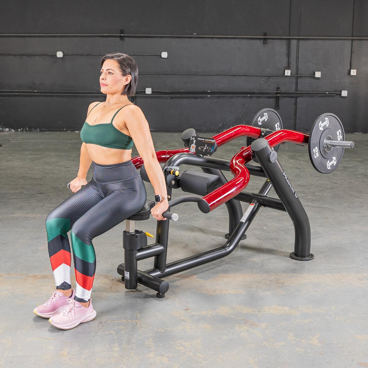 Woman performing seated dips on a black and red Power Leverage V2 machine with weight plates.