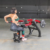 Thumbnail for Woman in green sports bra and black leggings using a black and red seated dip/triceps press machine.
