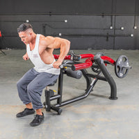 Thumbnail for Man performing seated dips on a black and red Power Leverage V2 Seated Dip / Triceps Press machine.