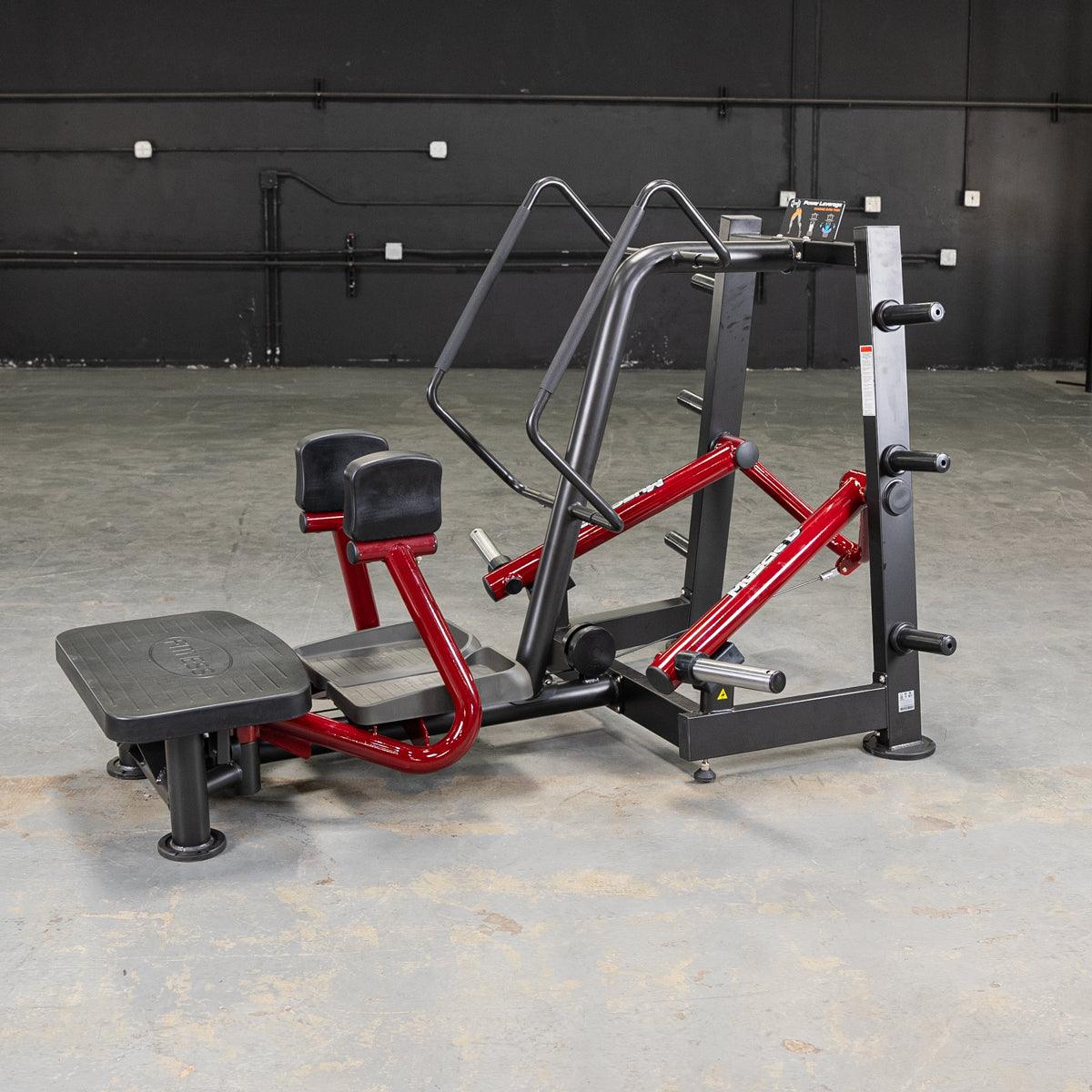 Red and black standing abductor machine in a gym.