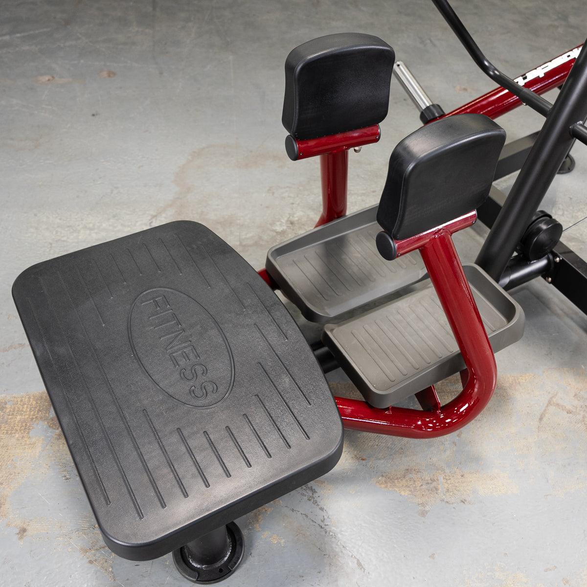 Close-up of a standing abductor machine's foot platform, footpads, and leg pads.