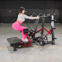 Thumbnail for Woman using a red and black standing abductor machine in a gym.