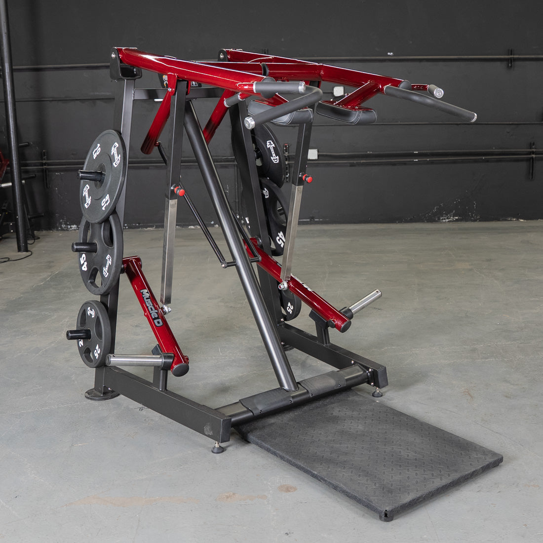 Red and black Viking press and calf raise machine with weight plates in a gym.