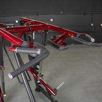 Thumbnail for Close-up of a red Viking press machine with black padded handles and arm rests.