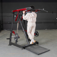 Thumbnail for Woman using a red and black Viking press machine with weight plates in a gym.