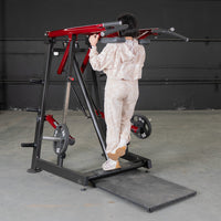 Thumbnail for Woman using a red and black Viking press machine with weight plates.