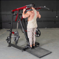 Thumbnail for Man using a red and black Viking press/calf machine with weight plates in a gym.