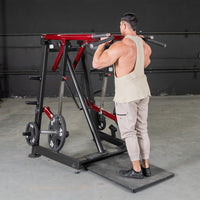 Thumbnail for Man using a red and black Viking press/calf machine with weight plates in a gym.
