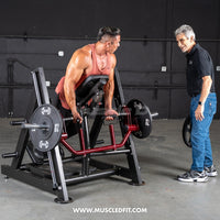 Thumbnail for Man using a chest-supported linear bearing row machine with a trainer watching.