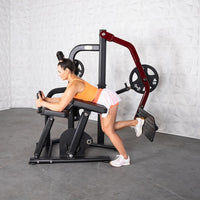 Thumbnail for Woman using a black and red plate-loaded glute kickback machine.