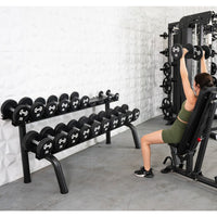 Thumbnail for Woman lifting dumbbells on an incline bench, with a rack of dumbbells in the foreground.