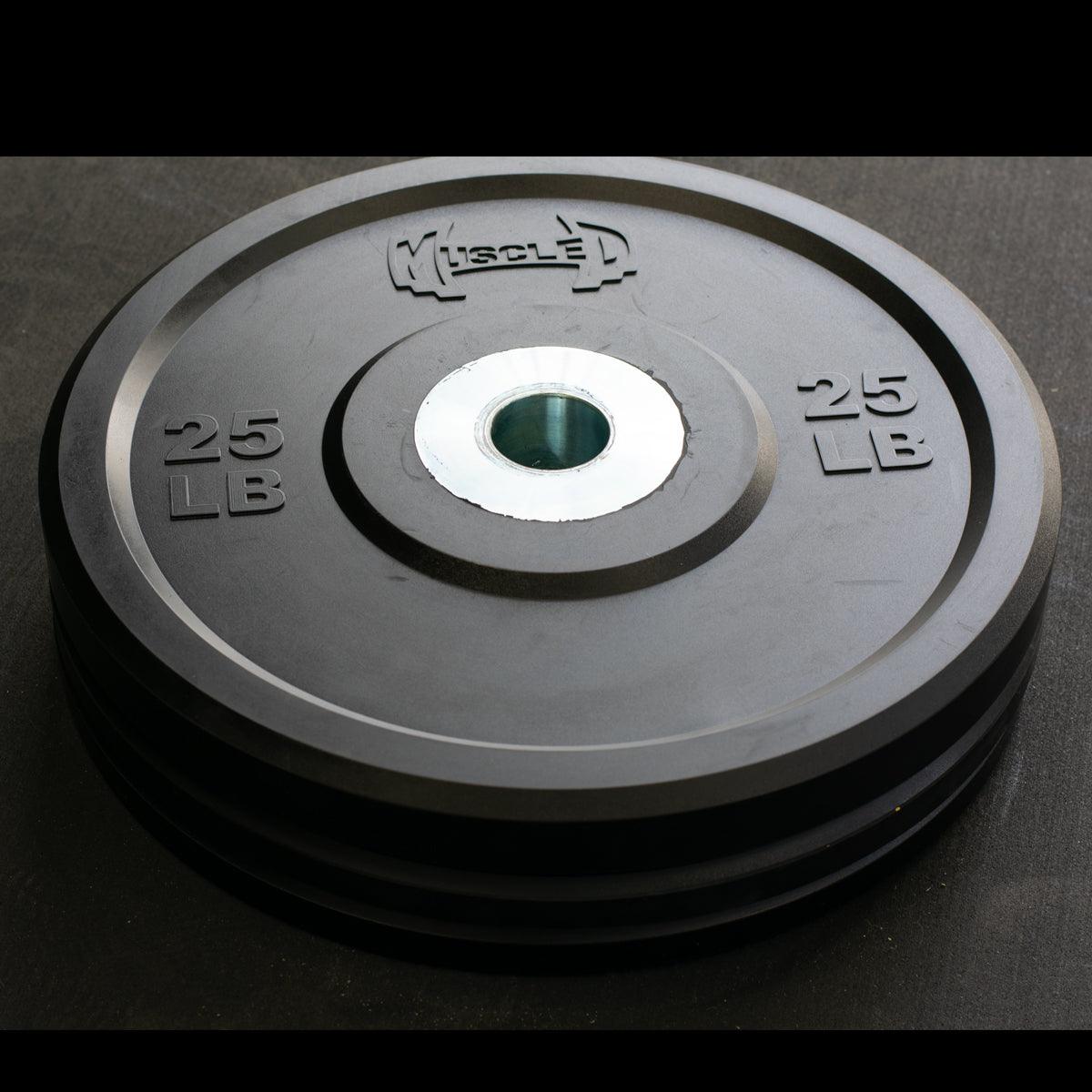 Black 25 LB bumper plate with "MUSCLE D" logo and steel center hub.