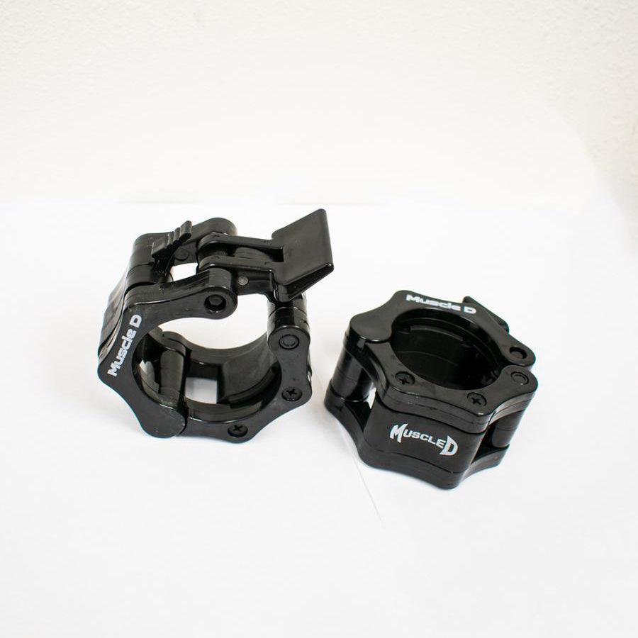 Pair of black Olympic barbell collars with "Muscle D" logo, one open and one closed.