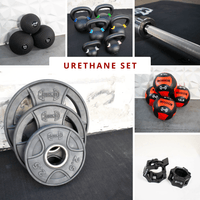 Thumbnail for Various gym equipment: weight plates, kettlebells, medicine balls, barbell, and barbell collars.