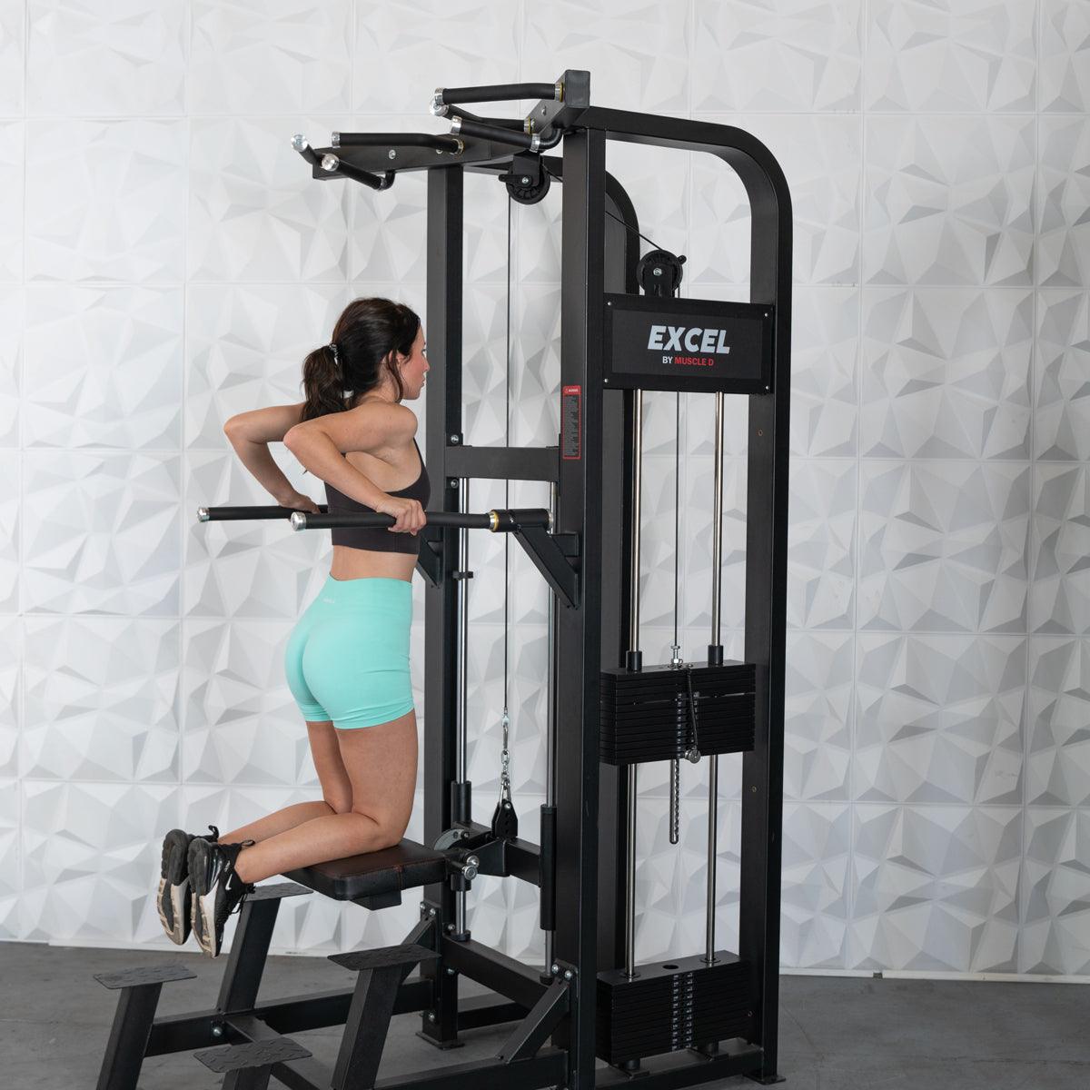 Woman doing dips on a black Excel assisted chin/dip combo machine with a collapsable knee pad.