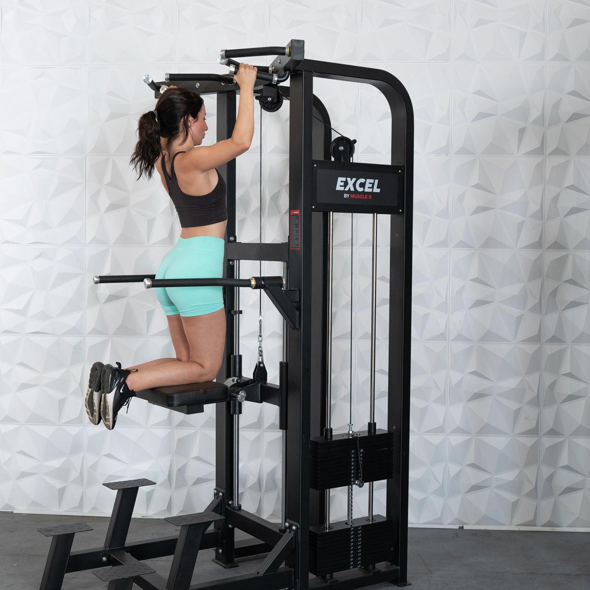 Woman performing an assisted chin-up on a black Excel chin/dip combo machine.