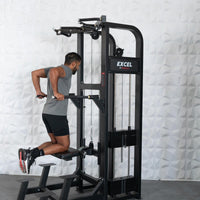 Thumbnail for Man performing assisted dips on a black Excel chin/dip combo machine with adjustable bars and knee pad.