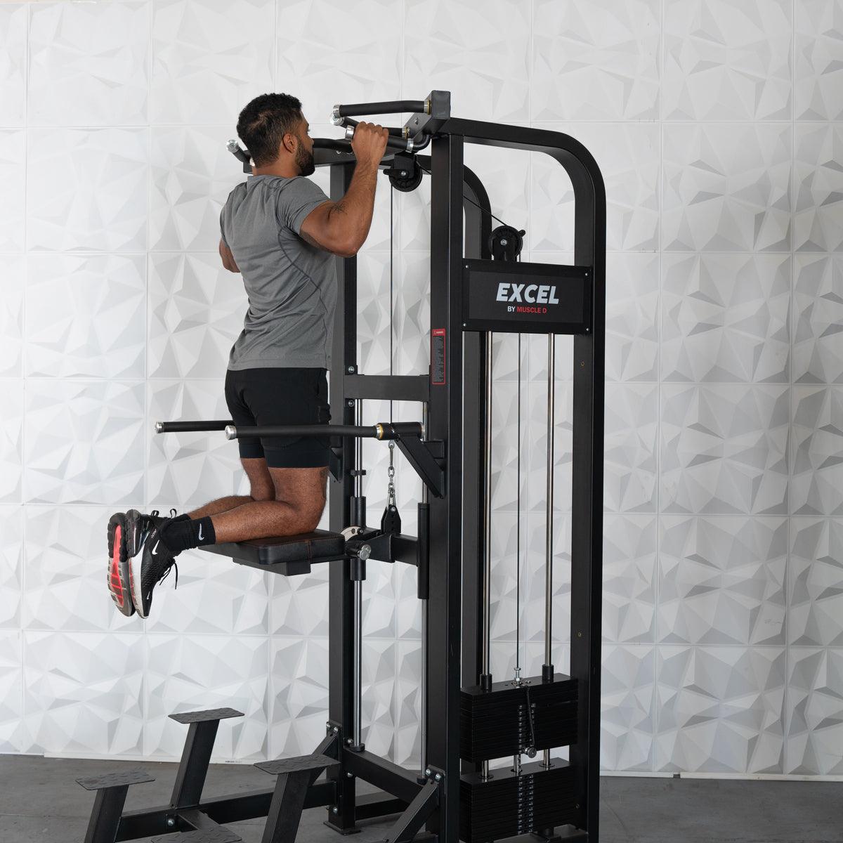 Man performing assisted chin-up on a black Excel selectorized chin/dip combo machine.