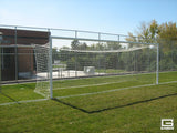 White soccer goal with net on a green grass field under a clear blue sky.