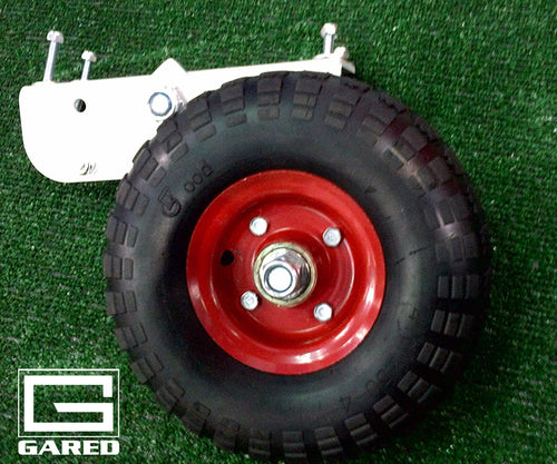 Black wheel with red hub attached to a white metal adapter bracket on green turf.