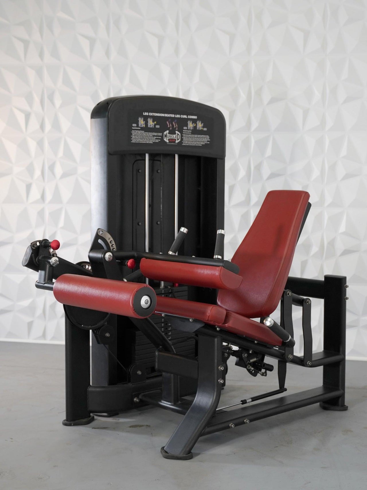 Black leg extension and curl combo machine with red padded seat and rollers.