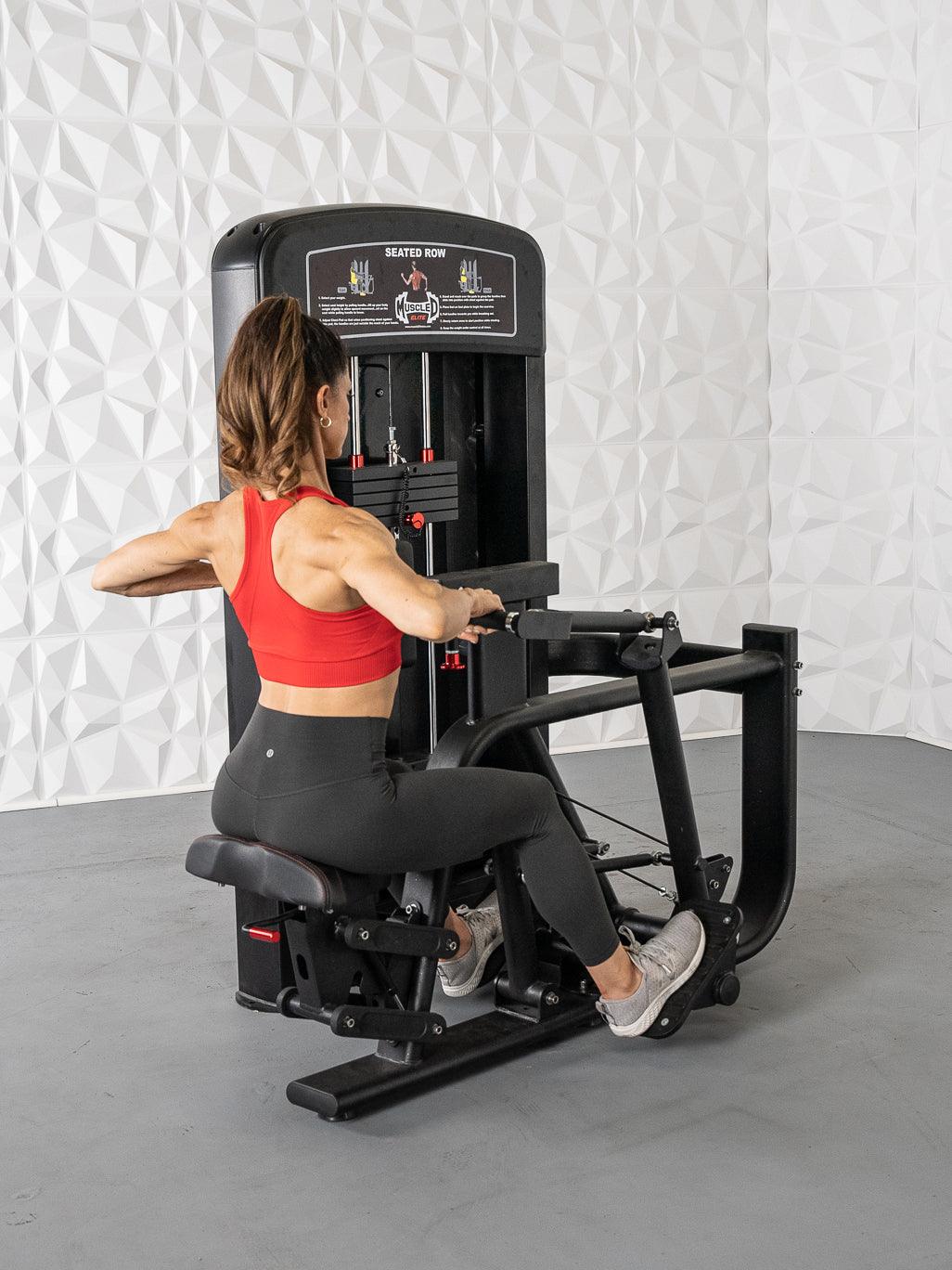 Woman in red top and black leggings using a black seated row machine with weight stack.