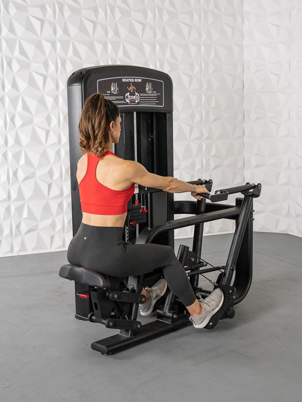 Woman in red top and black leggings using a black seated row machine.