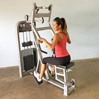 Thumbnail for Woman in red tank top and black capris using a silver seated row machine with pin selectorized weights.