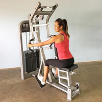 Thumbnail for Woman in a red tank top and black capris using a seated row machine.