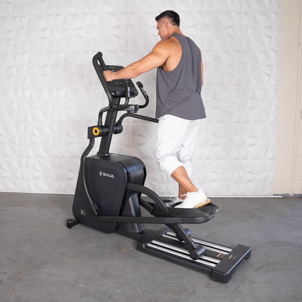 Man using a black commercial cross trainer elliptical machine.