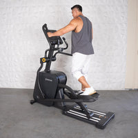 Thumbnail for Man using a black commercial cross trainer elliptical machine.
