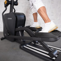 Thumbnail for Person's legs and feet in white sneakers on the foot pedals of a black elliptical cross trainer.