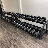 Thumbnail for Two black 2-tier dumbbell racks with hexagonal dumbbells in a gym.