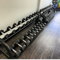 Thumbnail for Two rows of black hexagonal dumbbells with silver handles on black racks.