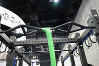 Thumbnail for Close-up of a black multi-grip pull-up bar on a squat stand, with a green resistance band attached.