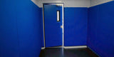 Small sensory room lined with blue padded walls and a blue padded door