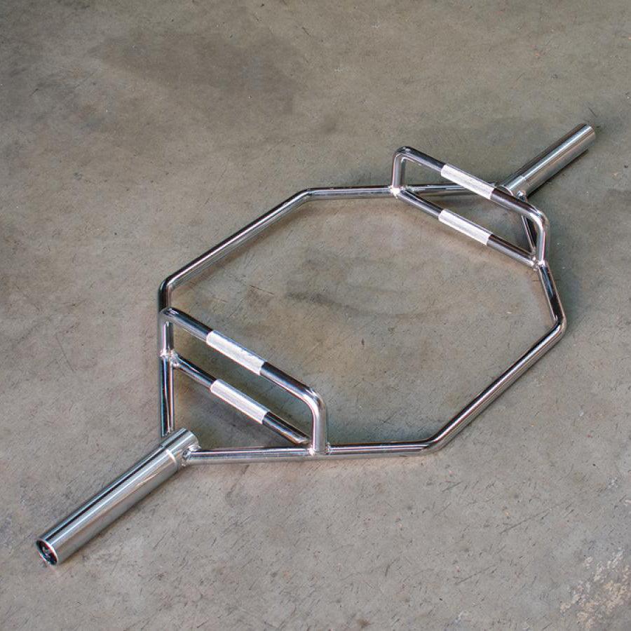 Shiny chrome hex trap bar with two sets of knurled handles on a concrete floor.