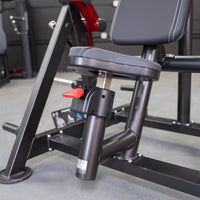 Thumbnail for Close-up of a black fitness machine seat with white stitching and a red adjustment lever.