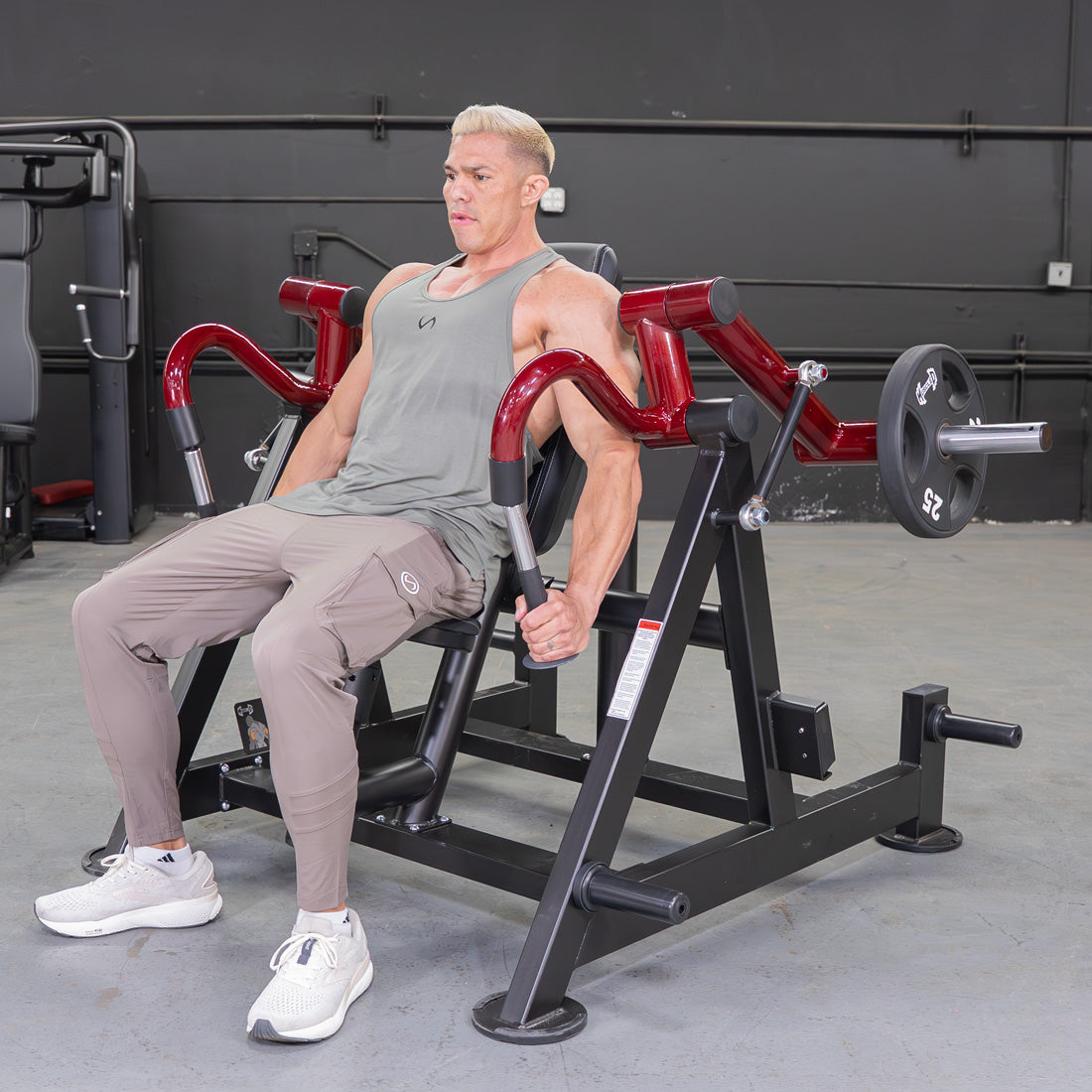 Man using a red and black Power Leverage V2 Hammer Grip Triceps machine in a gym.
