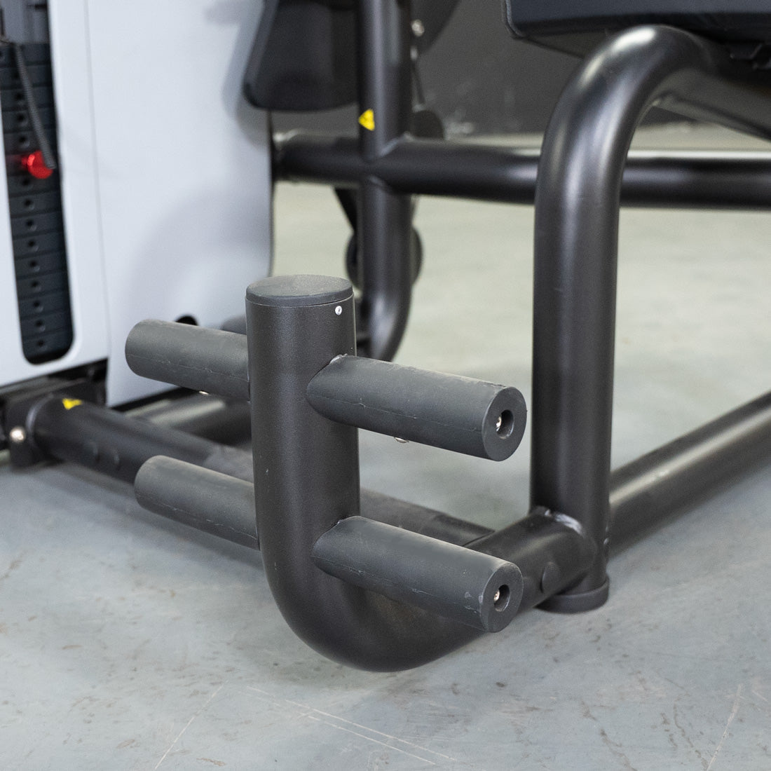 Close-up of the black, padded footrests and frame of the Vogue AB/Back Combo fitness machine.